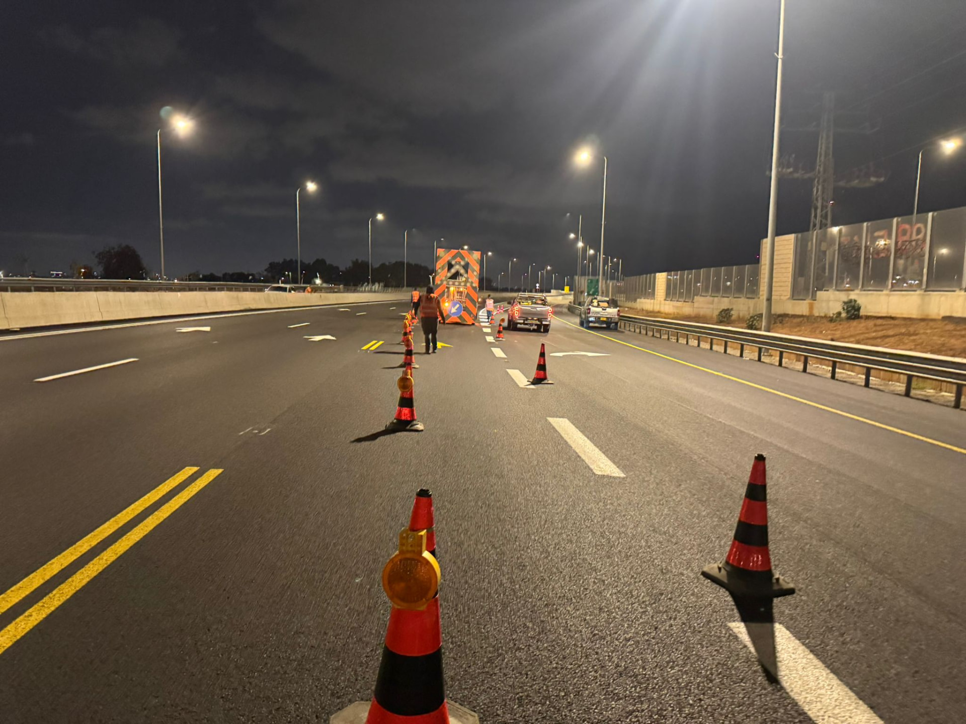 צוות אושר הדרך פורס קונוסים והסטת נתיב בכביש מהיר בלילה